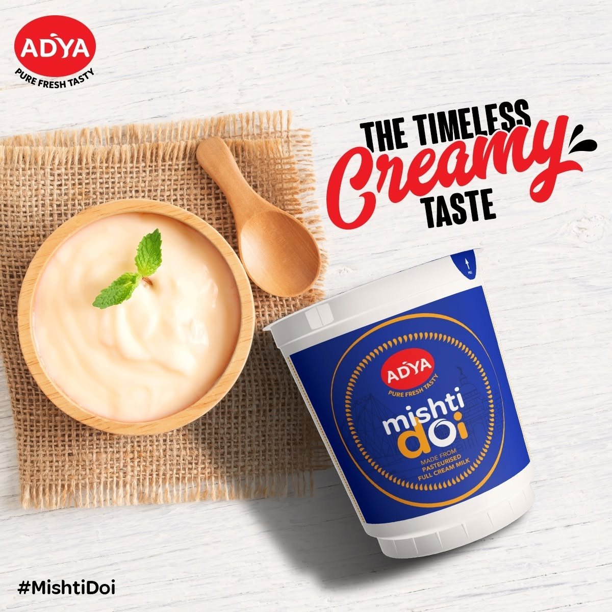 Adya Dairy Mishti Doi product campaign featuring a bowl of creamy sweet curd, wooden spoon and The Timeless Creamy Taste headline.